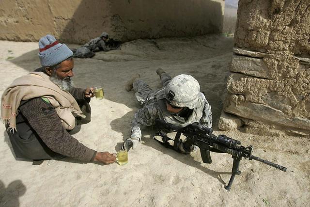 9 An Afghan man offers tea to soldiers